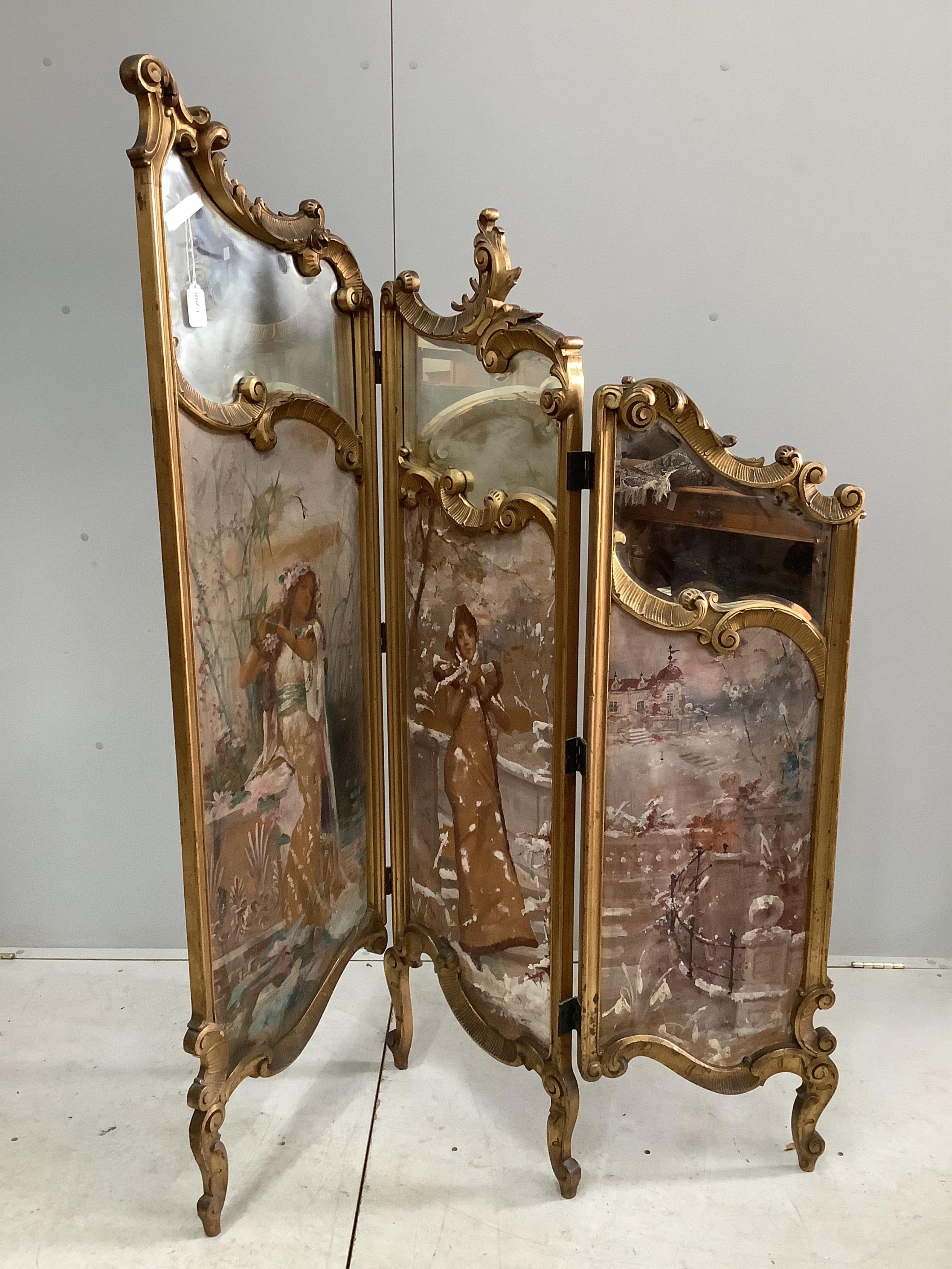 An early 20th century French carved giltwood three fold dressing screen with inset painted and printed panels, width 48cm, height 159cm. Condition - fair but some denting to the panels